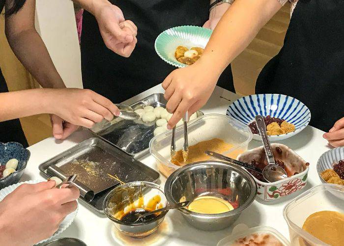 The table of a Japanese desserts class; guests are using the different tools and ingredients on the table.